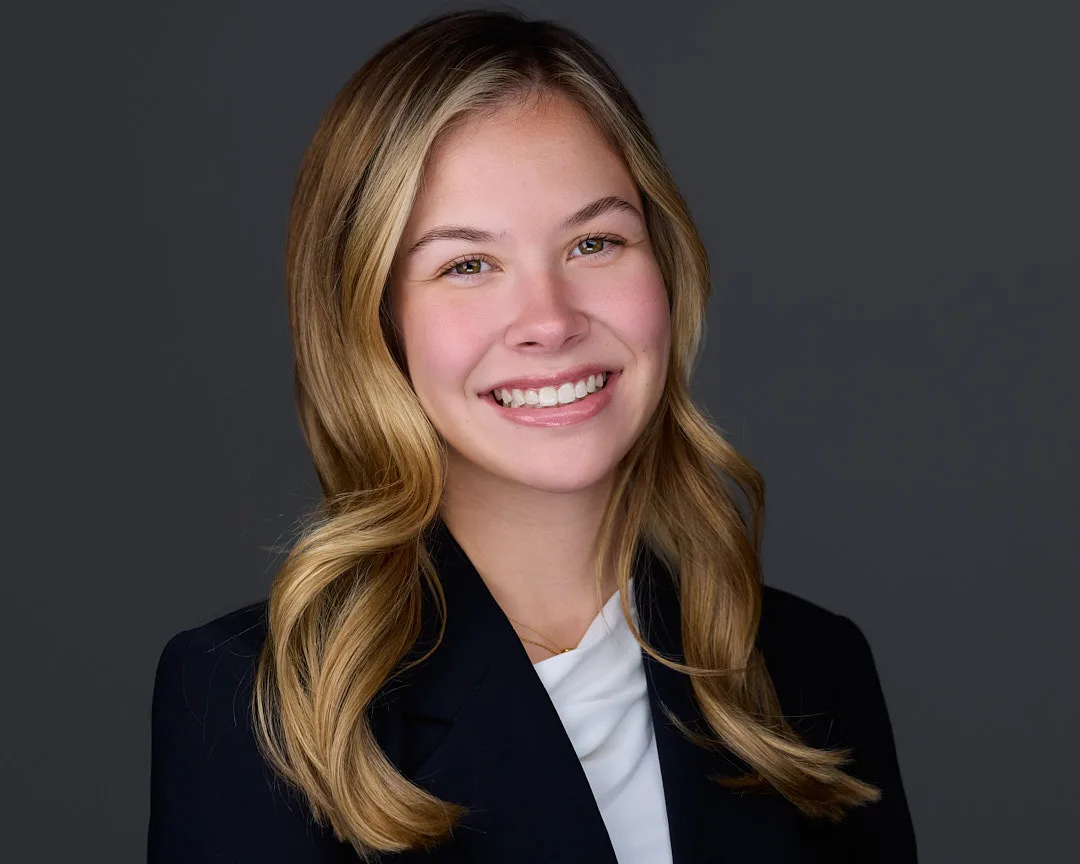 Professional corporate headshot demonstrating natural warmth and confidence