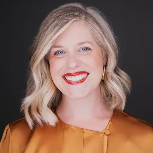 Attorney headshot of confident woman in professional attire against dark background with studio lighting