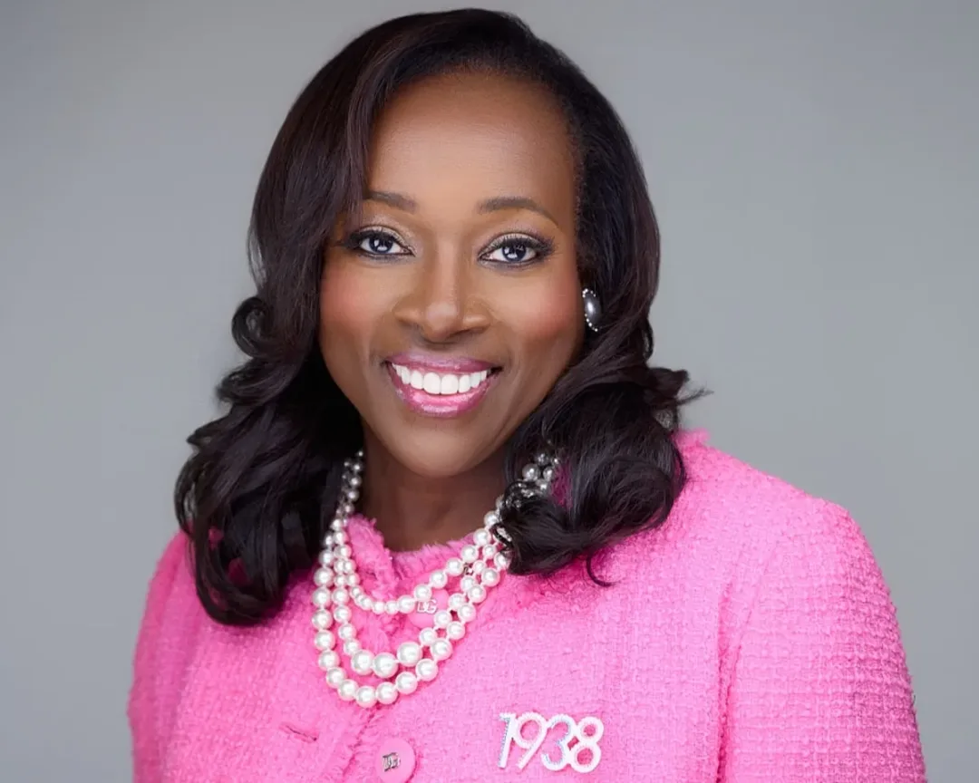 Fatimah Moody attorney headshot in pink cardigan and pearls, conveying warmth and professional authority for legal practice