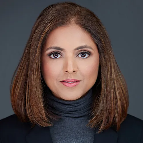 Sireesha Ganti LinkedIn headshot wearing charcoal turtleneck with poised expression and calm demeanor against gray studio backdrop
